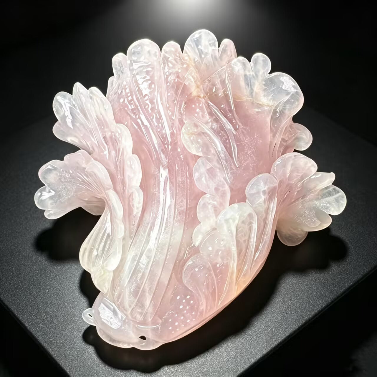 Hand carved natural rose quartz cabbage sculpture showing translucent pink layered leaves and floral details