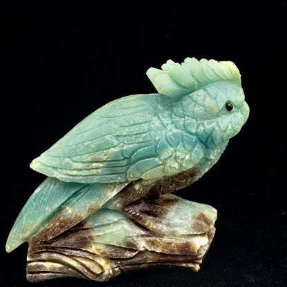 The Amazonite parrot figurine placed next to an illustration of the throat chakra, symbolizing its power to enhance communication.