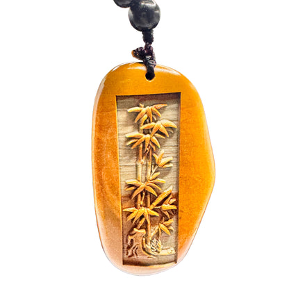 The natural stone bamboo charm suspended from a brown leather cord, perfect for daily spiritual jewelry.