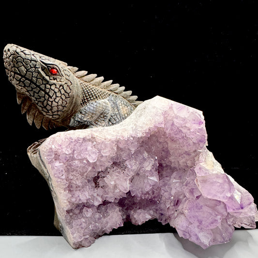 A close-up of the unique Lizard Eagle figure carved from a natural purple amethyst cluster.