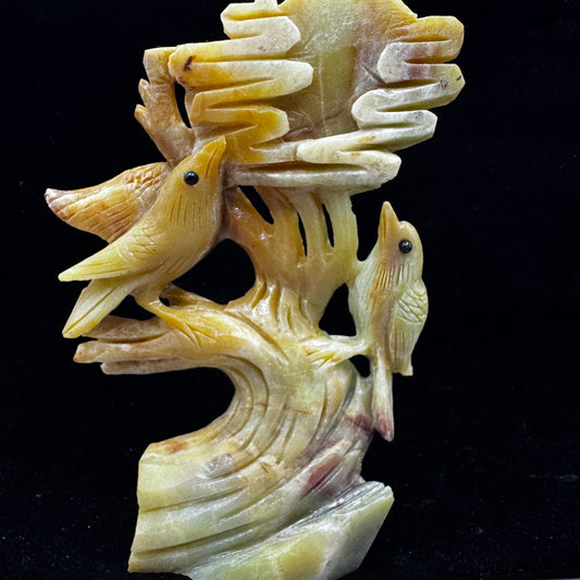 A close-up shot of the hand-carved amazonite bird sitting on a detailed flower.