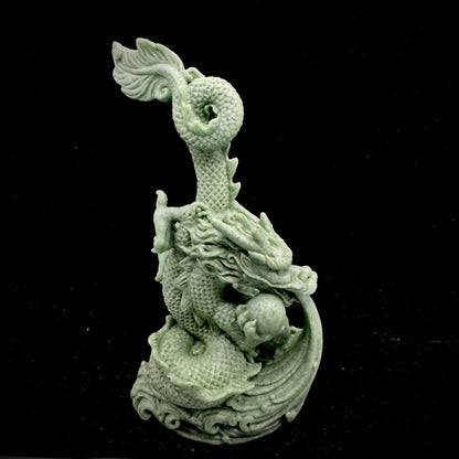 A detailed front view of the hand-carved bluestone dragon showing its fierce expression and scales.
