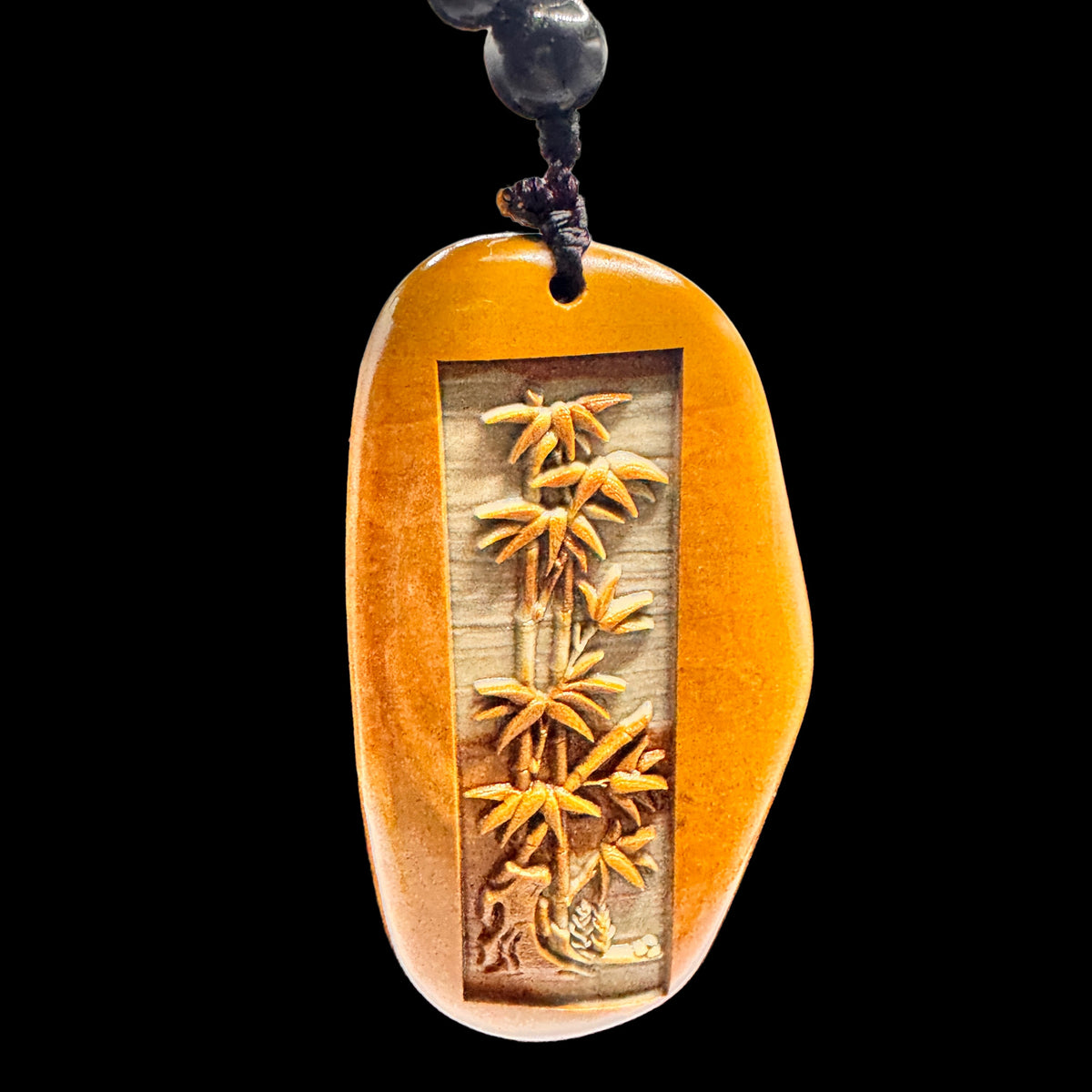Front view of the Songhua stone bamboo pendant showing detailed carving and natural green stone texture for growth and resilience.
