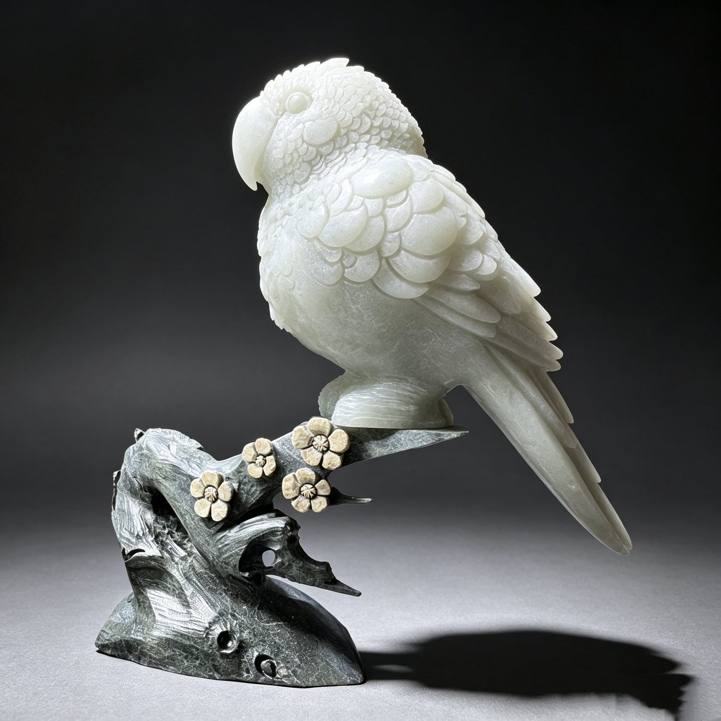 Hand carved natural stone parrot figurine perched on a decorative stone branch, three-quarter view.