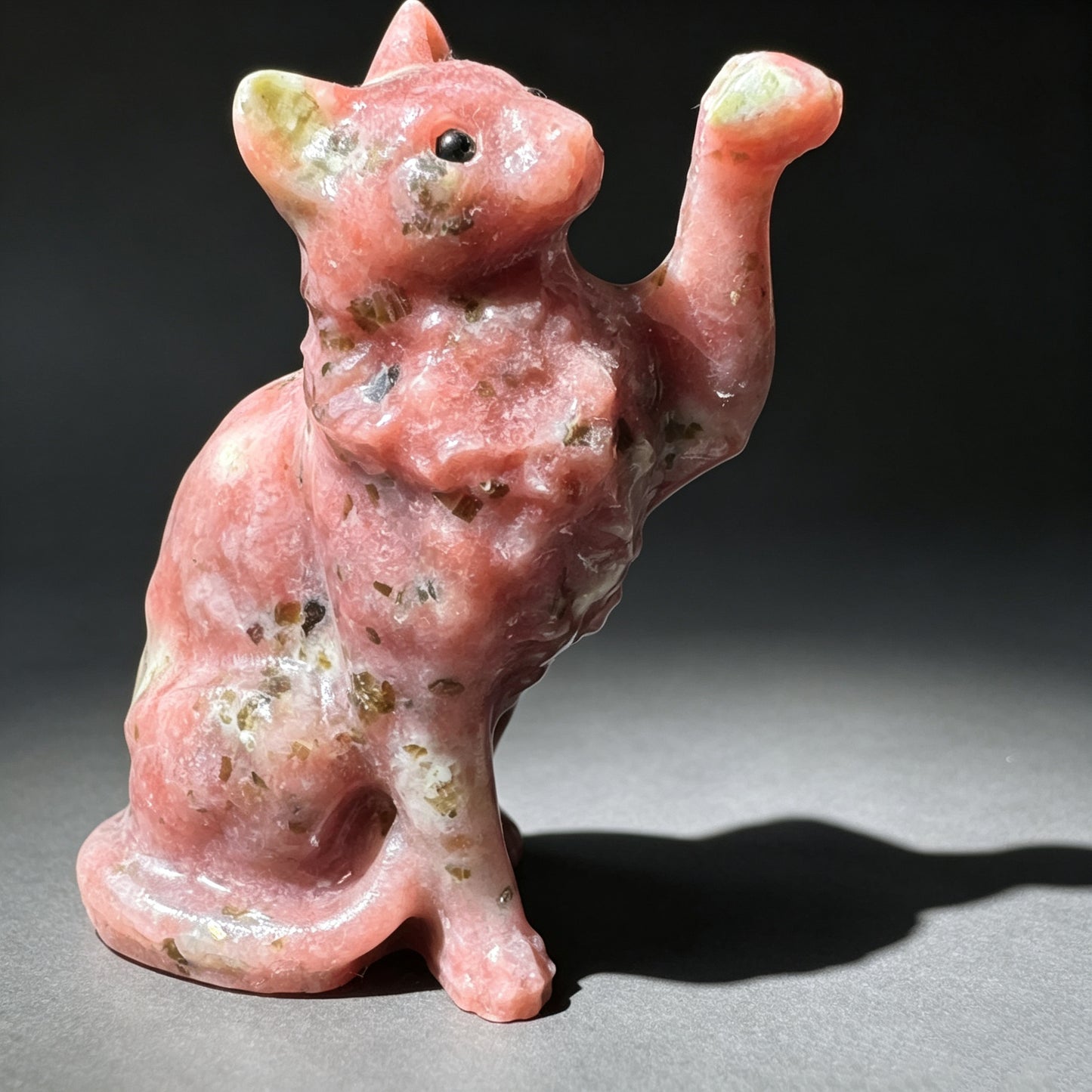 Natural stone carved raised paw cat sculpture with pink and natural stone patterns