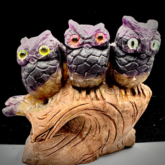 Hand carved natural rainbow fluorite owl trio sculpture on a wooden stand
