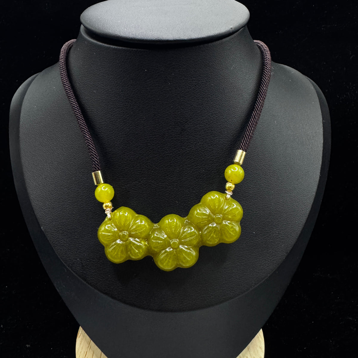 The model wears a necklace, with the pendant positioned at the solar plexus.