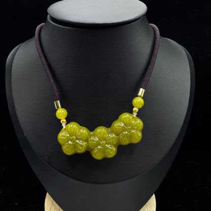 The model wears a necklace, with the pendant positioned at the solar plexus.