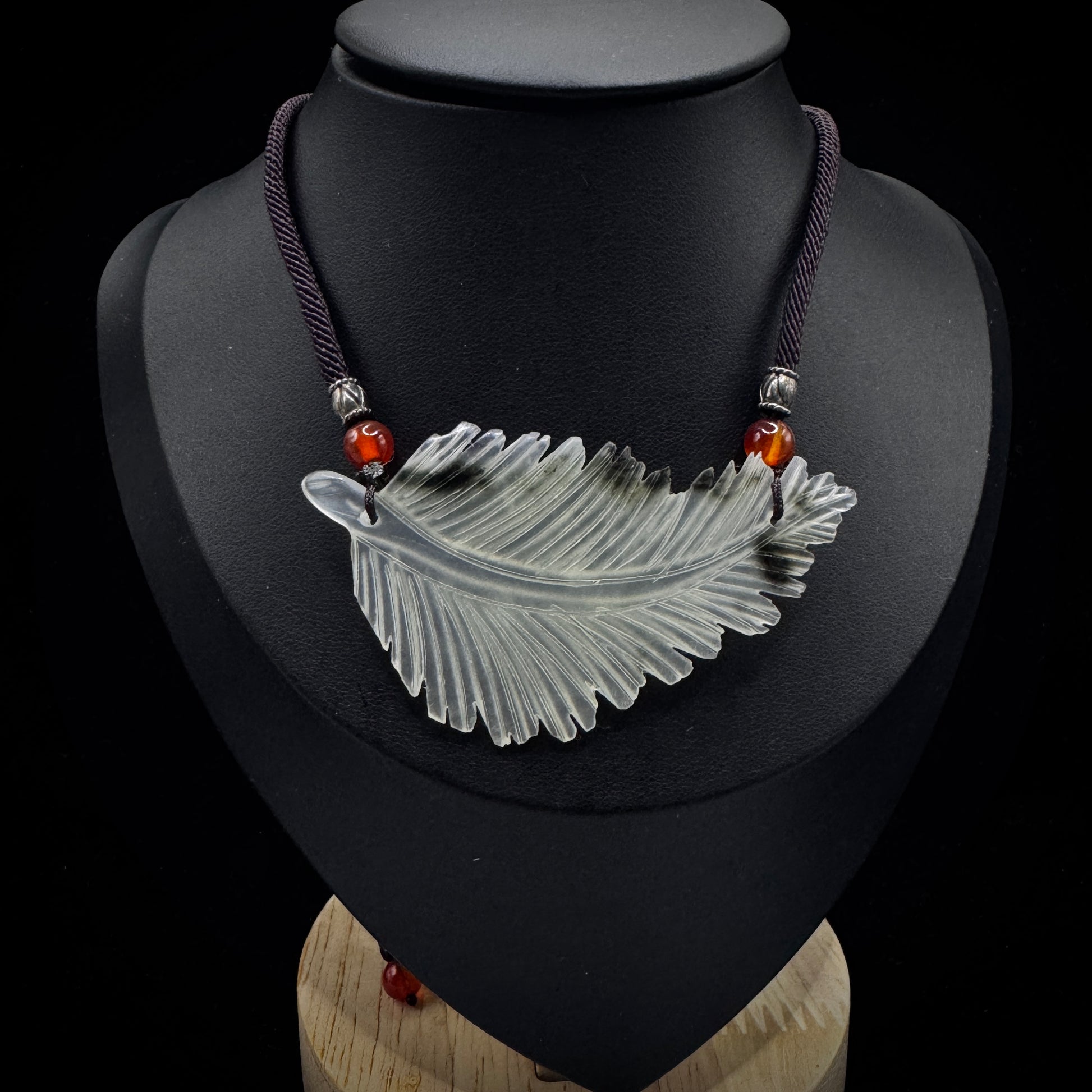 Close up of feather talisman showing natural stone texture and veins