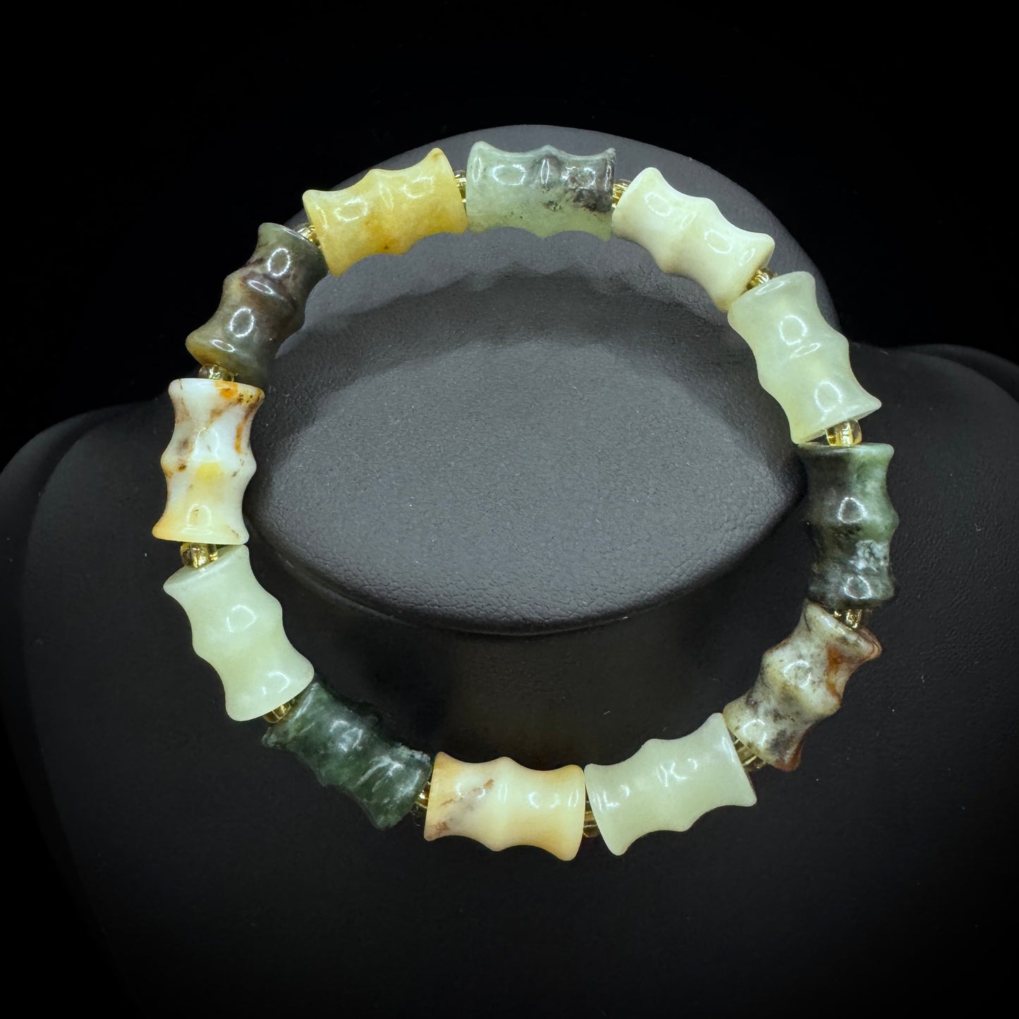 The natural Xiuyu jade bamboo node bracelet is displayed under natural light, showcasing its soft green hue and bamboo node design.