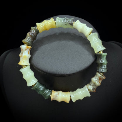 The natural Xiuyu jade bamboo node bracelet is displayed under natural light, showcasing its soft green hue and bamboo node design.